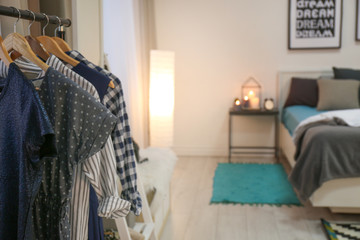 Rack with clothes in modern bedroom