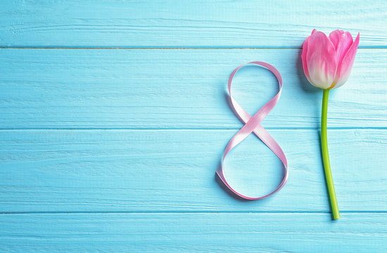 Beautiful tulip and ribbon on wooden background. International Women's day composition