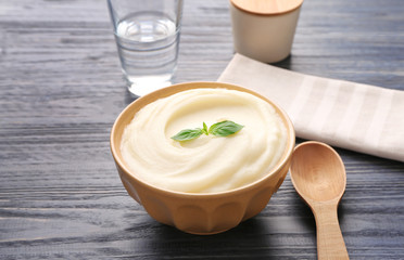 Bowl with mashed potatoes on wooden table