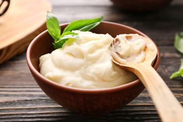 Mashed potatoes and spoon in bowl on wooden table