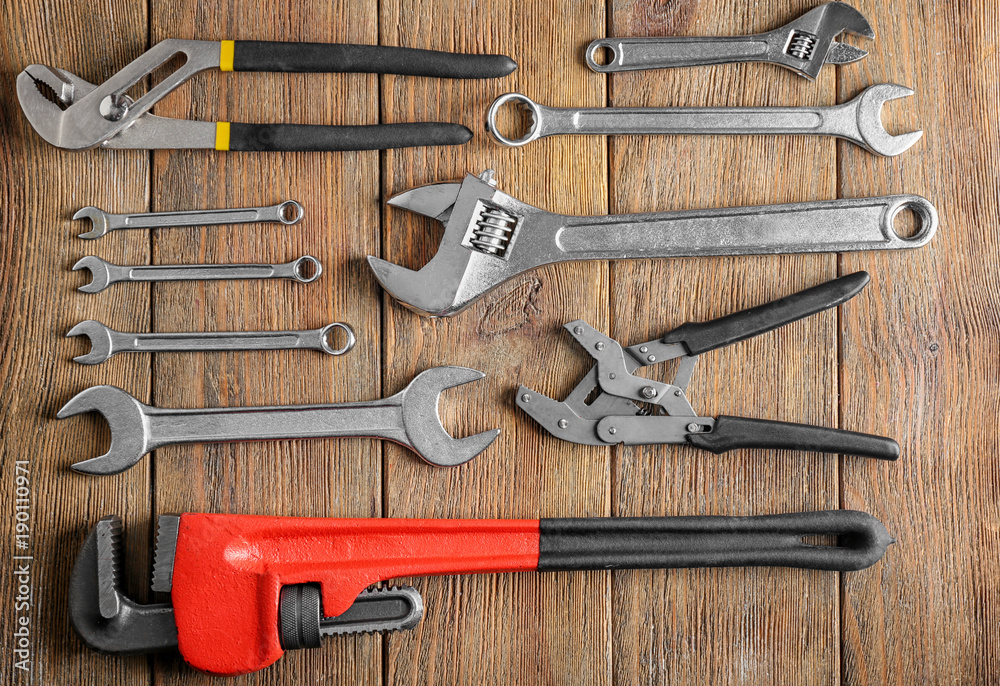 Wall mural Plumber's tools on wooden background