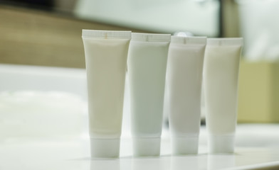 White container of  shower set in the hotel with warm background