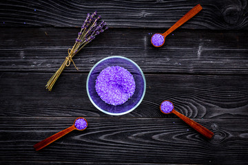 Fototapeta na wymiar Aromatic spa cosmetics. Lavender violet spa salt on dark wooden background top view