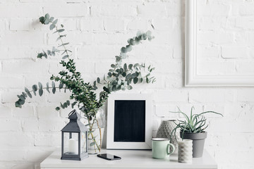 houseplants with blank chalkboard in front of white brick wall, mockup concept