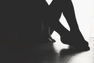 Sexy picture with woman holding arm between legs in low-key lighting and low contrast