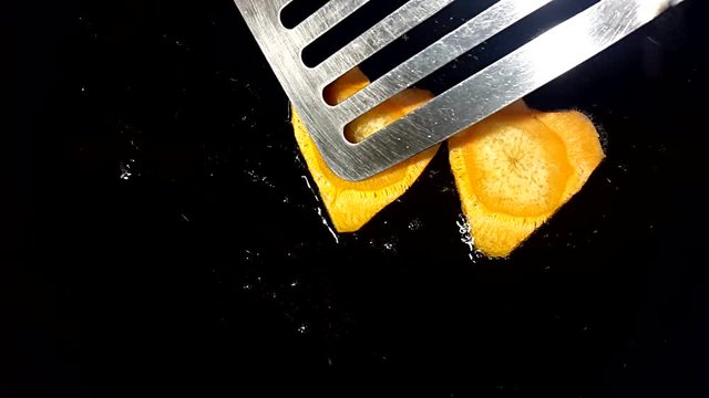 Fry carrots in the shape of heart in a frying pan