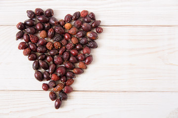heart of dry dog rose on the wooden background.healthy lifestyle concept.top view.copy space