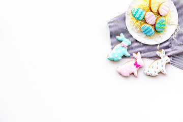 Easter background. Cookies in shape of easter bunny and easter eggs. White background top view space for text