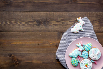 Easter bunny and easter eggs cookies. Sweets, pastry for Easter table. Dark wooden background top view copy space