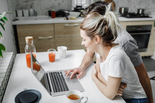 Couple using laptop at home.