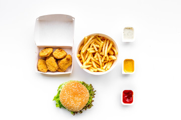 Fast food. Chiken nuggets, burgers and french fries on white background top view