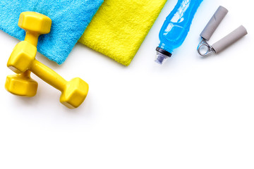 Fitness concept. Sport drink, dumbbells, towel on white background top view copy space
