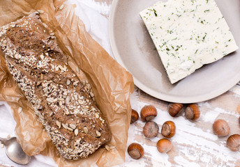 Fototapeta na wymiar Bread with cheese and huzelnuts for breakfast on board