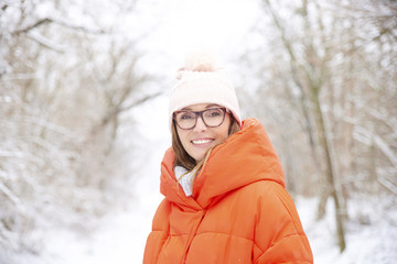 Close-up portrait of happy mature woman standing outside at snowy landscape and enjoy winter season. 