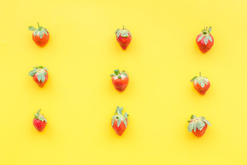 Fresh ripe strawberry. Pattern on yellow pastel background top view