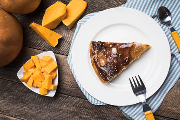 pieces of pumpkin and pie on plate on wood