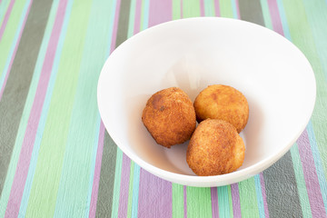 White compotera with three croquettes.