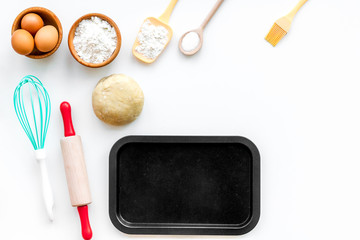 Roll out the dough. Dough ball near roller pin and other cookware on white background top view copy space