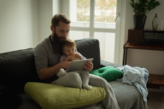 Father and son using digital tablet