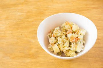 Potato salad in a white compotera.