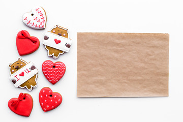 Sweet gift on Valentine's Day. Heart shaped cookies and bear with lettering I love you on white background top view mock up