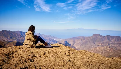 Poster Looking at view of Canary Island Gran Canaria / Woman sitting on top of a mountain © marako85