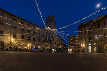 The moon above Piazza della Cisterna in San Gimignano, Siena, Tuscany, Italy - obrazy, fototapety, plakaty