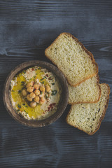 HUmus in the wooden bowl with bread slices,selective focus