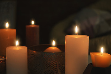 Fototapeta na wymiar Burning candles on blurred background