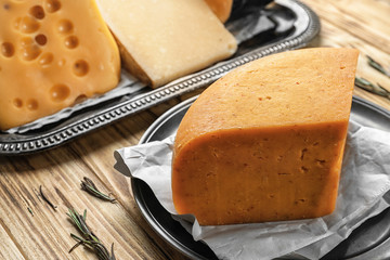 Piece of delicious cheese on wooden table