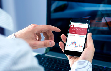 Man checks bitcoin rates at smartphone forex application. Interface created in graphic program