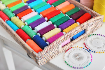 Set of color sewing threads with pins on table