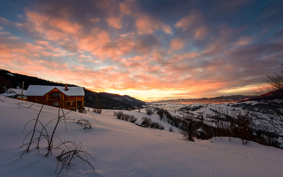 winter sunrise with red clouds in the village