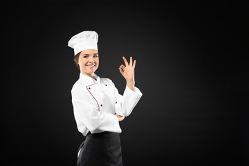 Portrait of female chef on black background