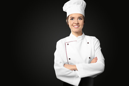 Portrait of female chef on black background