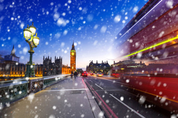 Fototapeta na wymiar Big Ben and Westminster bridge on a cold winter night with falling snow, London, United Kingdom
