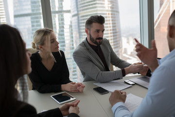 The business people sit at the table and work in the office.