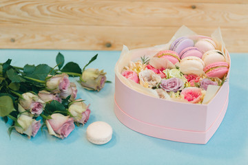 Gift box in the form of a heart with almond macaroons and flower arrangement. Present for the day of lovers. Valentine's Day and March 8.