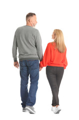 Mature couple in casual clothes walking on white background
