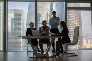 Business people working in an office on a background of panoramic windows.