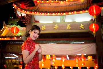 Portrait of beautiful asian woman wear cheongsam on light of lantern background,Happy chinese new year,Thailand people