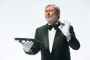 Senior waiter holding tray