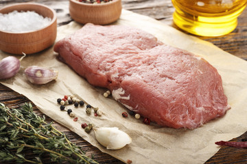 Raw steak with spices . Next to it is a red hot pepper, colorful pepper, olive oil
