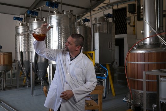 Male worker checking quality of gin