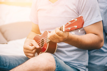 Selective Focus of Musician Man are Playing Ukulele in Living Room - Lifestyle Concept