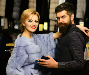 Luxury and relationship concept. Couple in love tries expensive overcoats