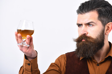 Barman in elegant uniform with serious face serves cognac.