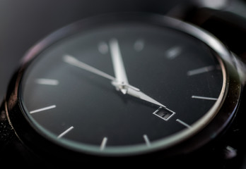 Black wrist watch closeup with date showing -  time, aging, wasting time, deadline concept and idea