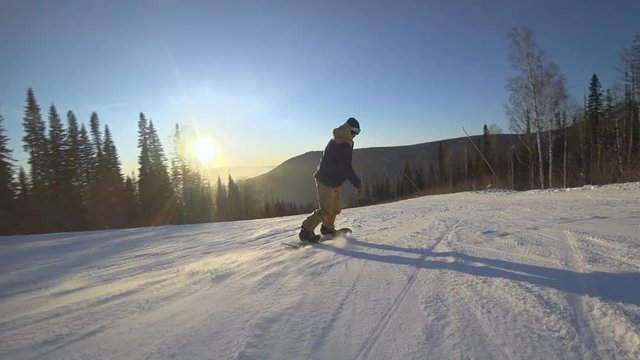 Active man snowboarder riding on slope. Snowboarding closeup.