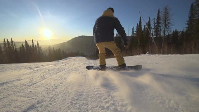 Active man snowboarder riding on slope. Snowboarding closeup.